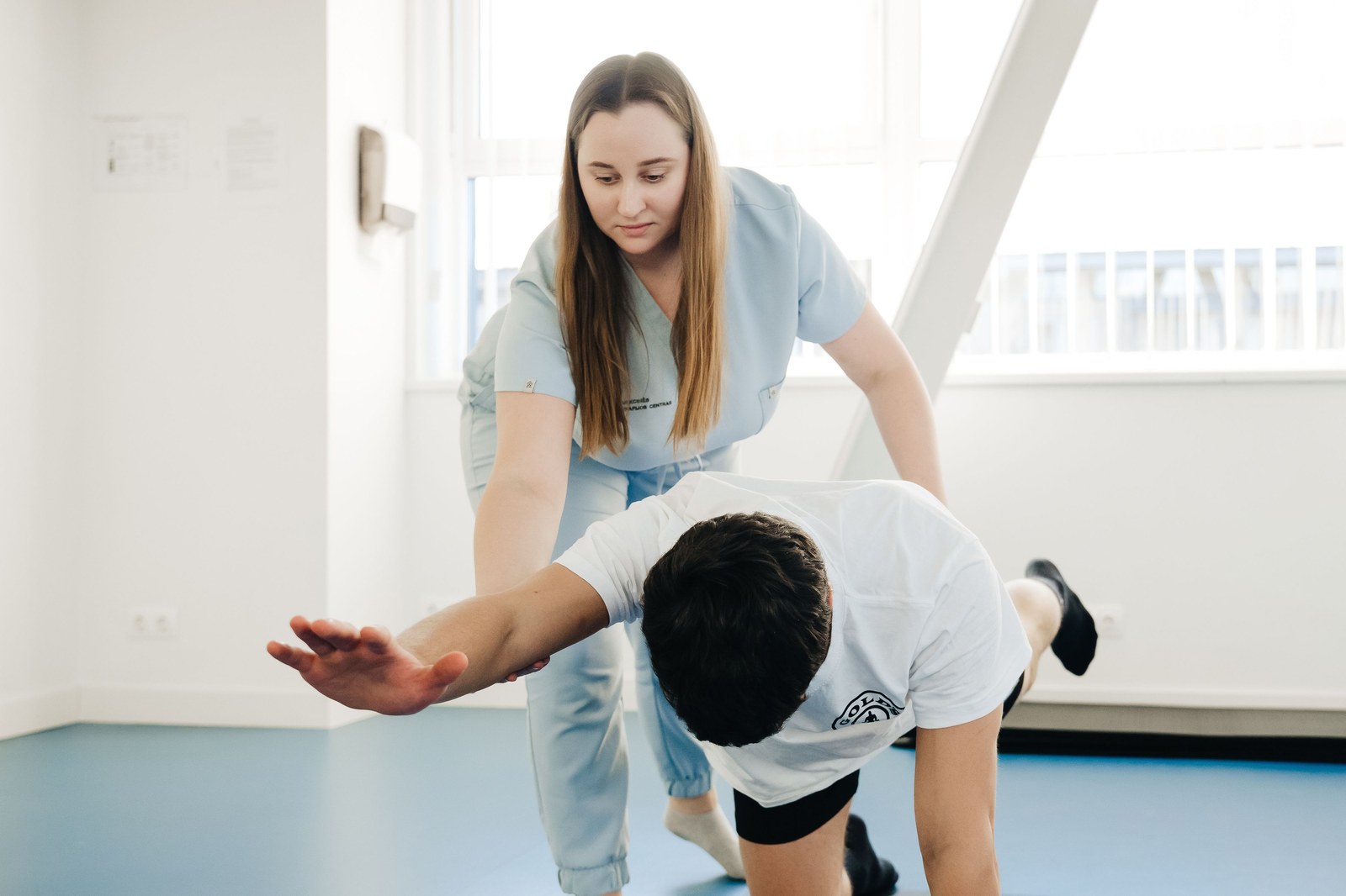 Fisioterapeuta auxiliando paciente em exercício de alongamento no Dia do Fisioterapeuta