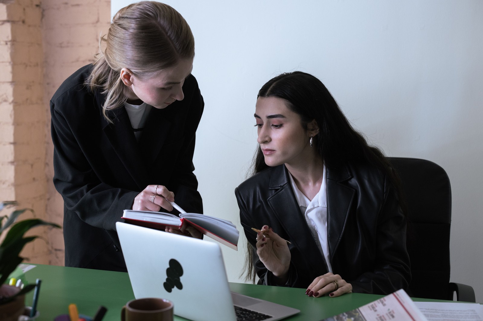 Dia da Secretária: a data que também virou lei no Brasil Duas colegas de trabalho colaborando em uma mesa de escritório, homenagem ao Dia da Secretária