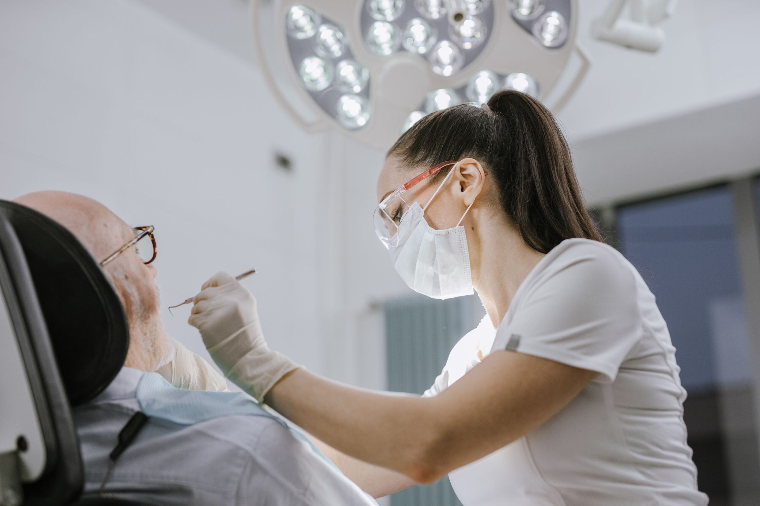 Dia do Dentista: 5 curiosidades sobre a profissão e a data de 25 de outubro Dentista atendendo um paciente em consultório moderno